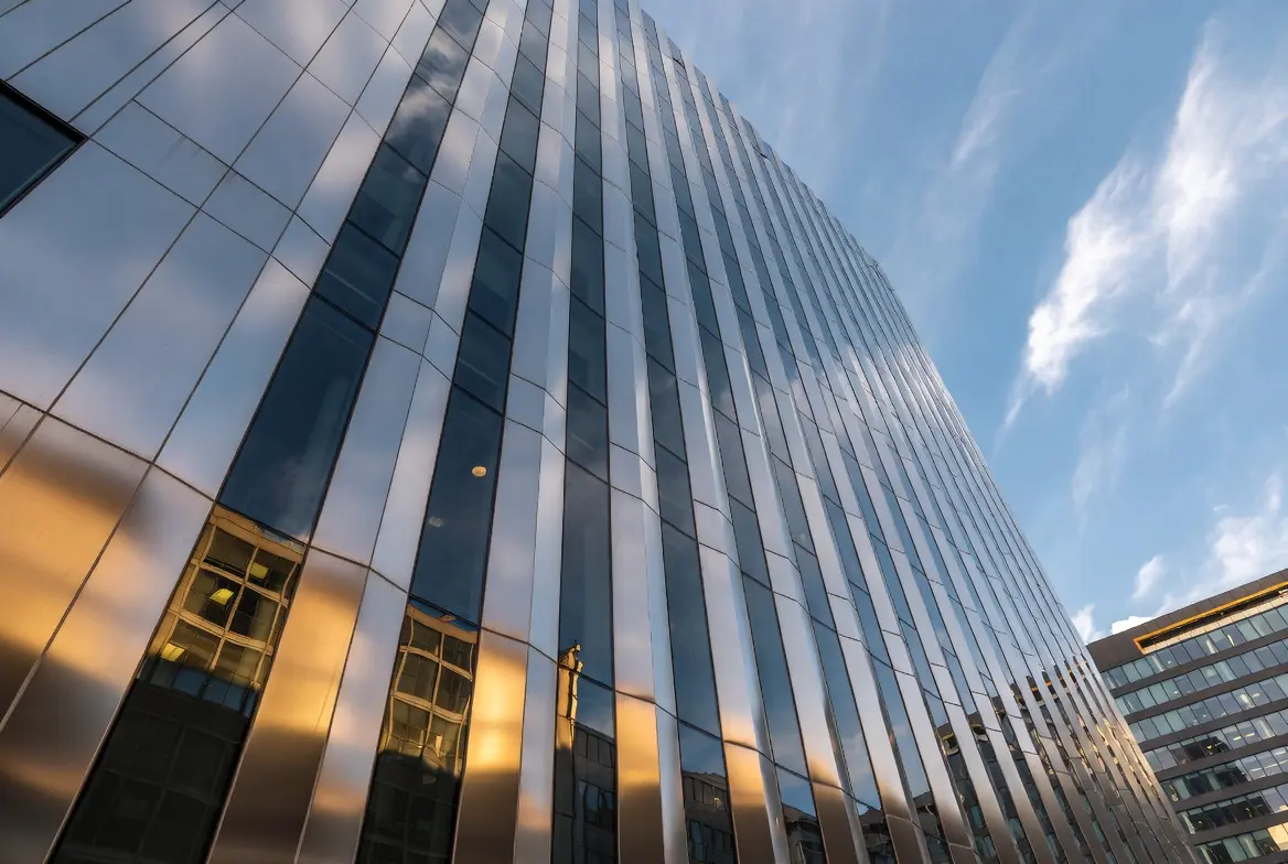 Modern high-rise building featuring stainless steel curtain wall exterior with reflective glass panels